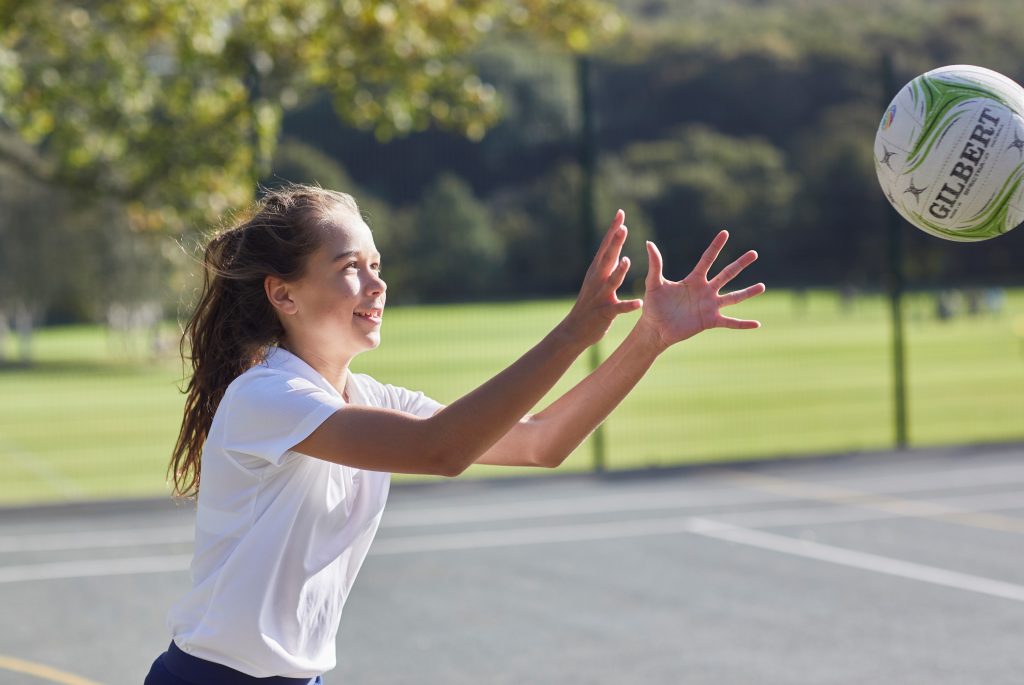 Netball - Girl with netball v2 | Woodhouse Grove School